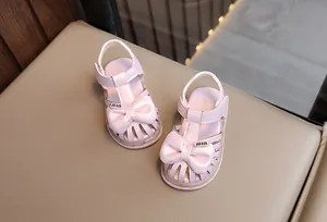 Nahaufnahme von rosa LED-Sandalen für Kleinkinder mit süßer dekorativer Schleife.