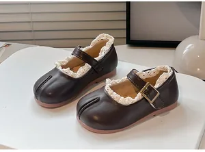 Primer plano de zapatos Tabi Mary Jane marrones para niña con encaje blanco decorativo