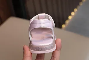 Nahaufnahme der Ferse von rosa leuchtenden Sandalen für Kleinkinder mit Klettverschluss.