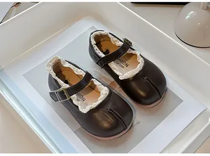 Primer plano de zapatos Mary Jane marrones para niña con diseño tabi y borde de encaje