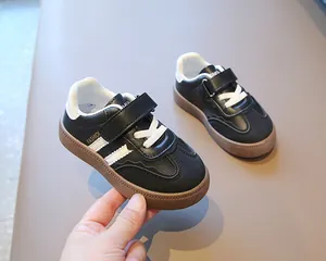 Nahaufnahme von stylischen schwarz-weißen atmungsaktiven Kinderschuhen mit Gummisohle