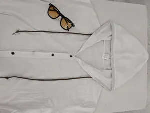 Vue détaillée d'une chemise à capuche en lin blanc respirant avec cordons marron.