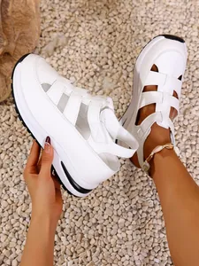 Detailed macro view of white hollow platform sandals with thick sole on pebble ground