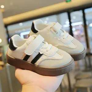 Atmungsaktive Retro-Sneaker für Kinder mit Klettverschluss in Off-White und Schwarz.