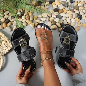 Vista dettagliata di eleganti sandali bassi da donna con fibbia in nero e marrone