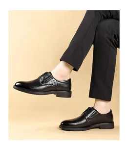 Detail view of men's breathable hollow black leather business casual lace-up shoes on model