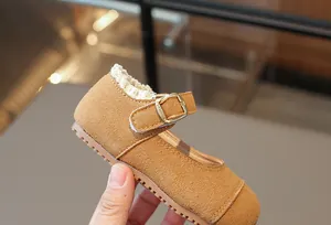 Detailansicht der braunen Wildleder-Mary-Janes für Mädchen mit Spitze und Metallschnalle.