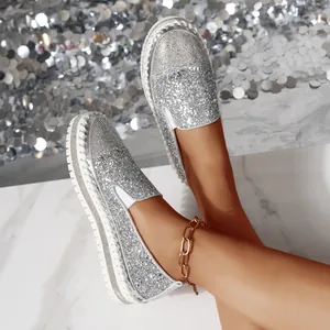Dettaglio di eleganti mocassini con zeppa glitter argento e punta ricoperta di strass