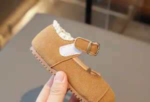 Detailansicht braune Wildleder-Mary-Janes für Mädchen mit weißem Spitzenbesatz und Schnalle.
