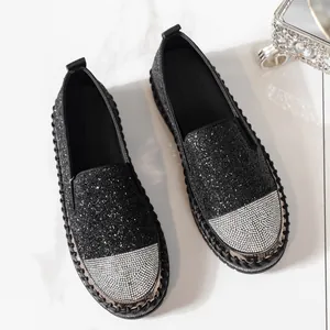 Dettaglio di mocassini neri glitterati con punta in strass luccicanti e design comodo
