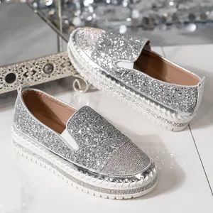 Dettaglio dei mocassini platform con glitter argento e accenti di strass sulla punta
