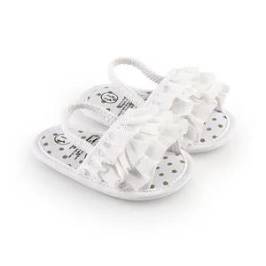 White ruffled baby walking shoes with gold polka dot insoles for infants.