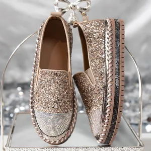 Dettaglio di mocassini glitter color oro champagne con strass e suola spessa alta