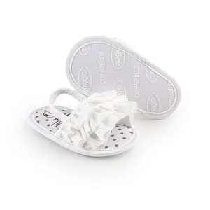 Detail view of white baby prewalker sandals featuring elegant ruffles and elastic back strap.