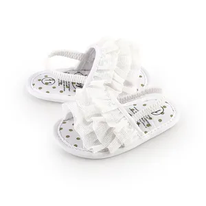 Detailed view of white ruffled baby pre-walker shoes with elastic heel strap and polka dot insoles
