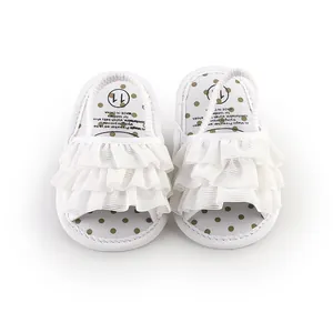 Detailed top view of white ruffled baby prewalker sandals with gold polka dots