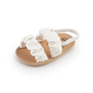White baby cloud sandals featuring soft sole and elegant ruffled straps detail view
