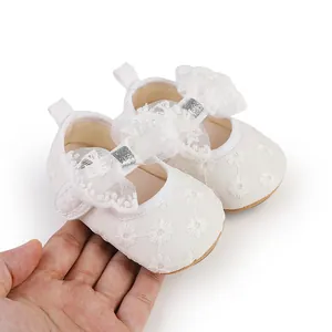 Detailed view of white lace baby girl princess shoes with large bow and soft sole