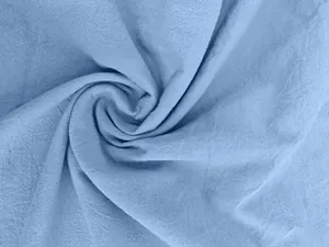 Gros plan sur la texture respirante d'un tissu en lin bleu clair pour chemises d'été hommes