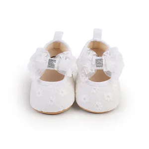 Detailed front view of white lace baby girl shoes with elegant floral embroidery and bows
