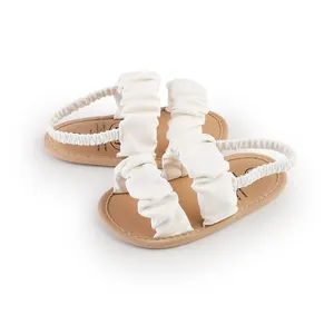 Detail shot of white ruffled baby girl walking sandals with elastic back straps.