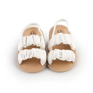 Detailed view of white ruffled baby sandals with elastic heel straps