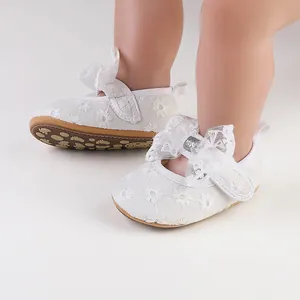 Detailed view of white floral lace baby shoes with decorative bow and soft non-slip sole