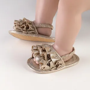 Macro view of golden ruffled baby walker sandals featuring glitter finish and elastic heel strap