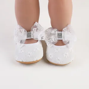 Detailed front view of white lace baby princess shoes with a large bow and glitter