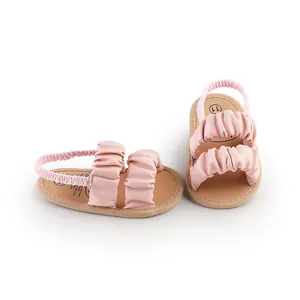Detailed view showing the soft ruffled cloud straps on these pink baby sandals.