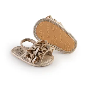 Detailed view of champagne gold ruffle baby pre-walker sandals with elastic back strap