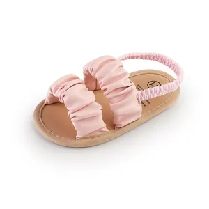 Detailed view of soft pink ruffled baby girl walking shoe with an elastic heel strap