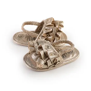 Detail of gold ruffled baby walking shoes with metallic texture and soft sole.