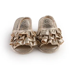 Close-up view of shimmering gold ruffled baby prewalker shoes with soft metallic fabric
