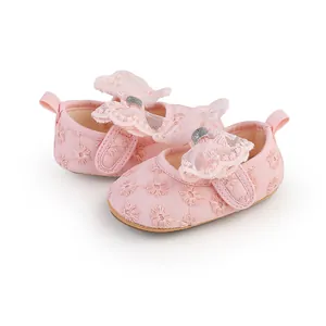 Close-up of pink baby girl princess shoes with delicate lace butterfly and floral embroidery