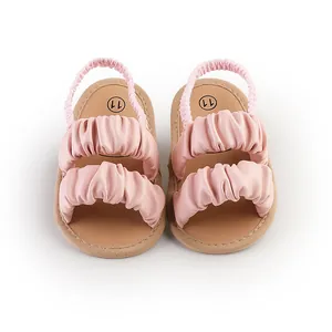 Close-up of pink ruffled summer baby girl sandals with elastic heel strap