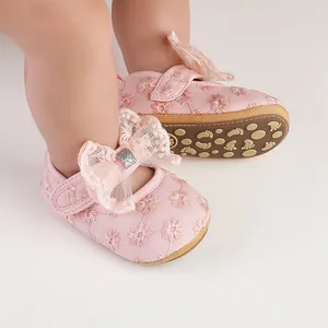 Close-up of pink baby girl princess walker shoes with floral lace and a decorative bow