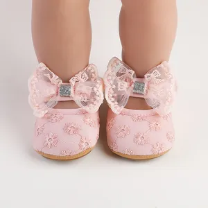 Close-up view of pink baby girl princess walking shoes featuring lace bows and floral embroidery