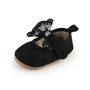 Close-up of black lace baby girl walker shoe with large bow and soft sole