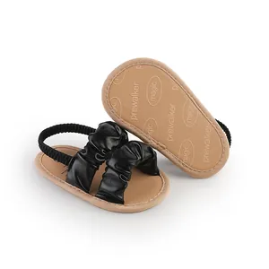 Close-up of black ruffled baby girl sandals with flexible prewalker sole for infants