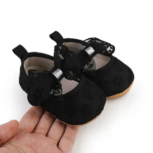 Detailed close-up view of black lace baby walker shoes with a large decorative bow