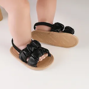 Detail view of black ruffle infant sandals with elastic heel strap for baby girls