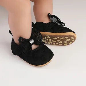 Close-up of black lace baby shoes with bow and anti-slip sole for toddlers