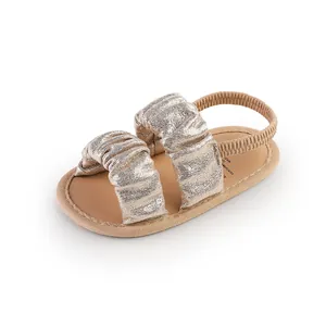 Close-up of sparkly gold ruffled cloud baby sandals with soft and elastic back strap