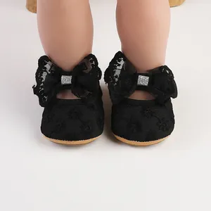Detailed view of black baby princess shoes with lace bow and elegant floral embroidery