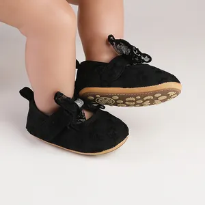 Detailed macro view of black lace baby shoes featuring a delicate bow and soft non-slip sole