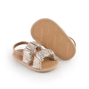 Detailed view of champagne gold baby pre-walker sandals with soft non-slip soles.