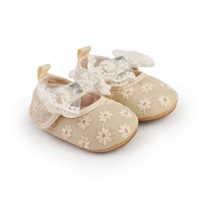 Detailed view of beige baby girl walking shoes with lace floral embroidery and bows