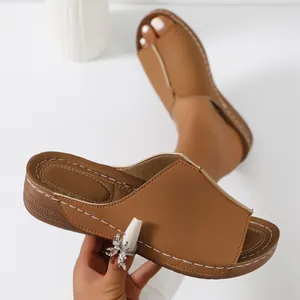 Close-up detailed view of tan wedge platform sandals with contrast stitching and open toe design