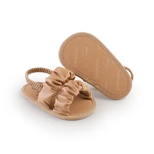 Detailed view of brown infant pre-walker sandals featuring ruched straps and elastic heel.